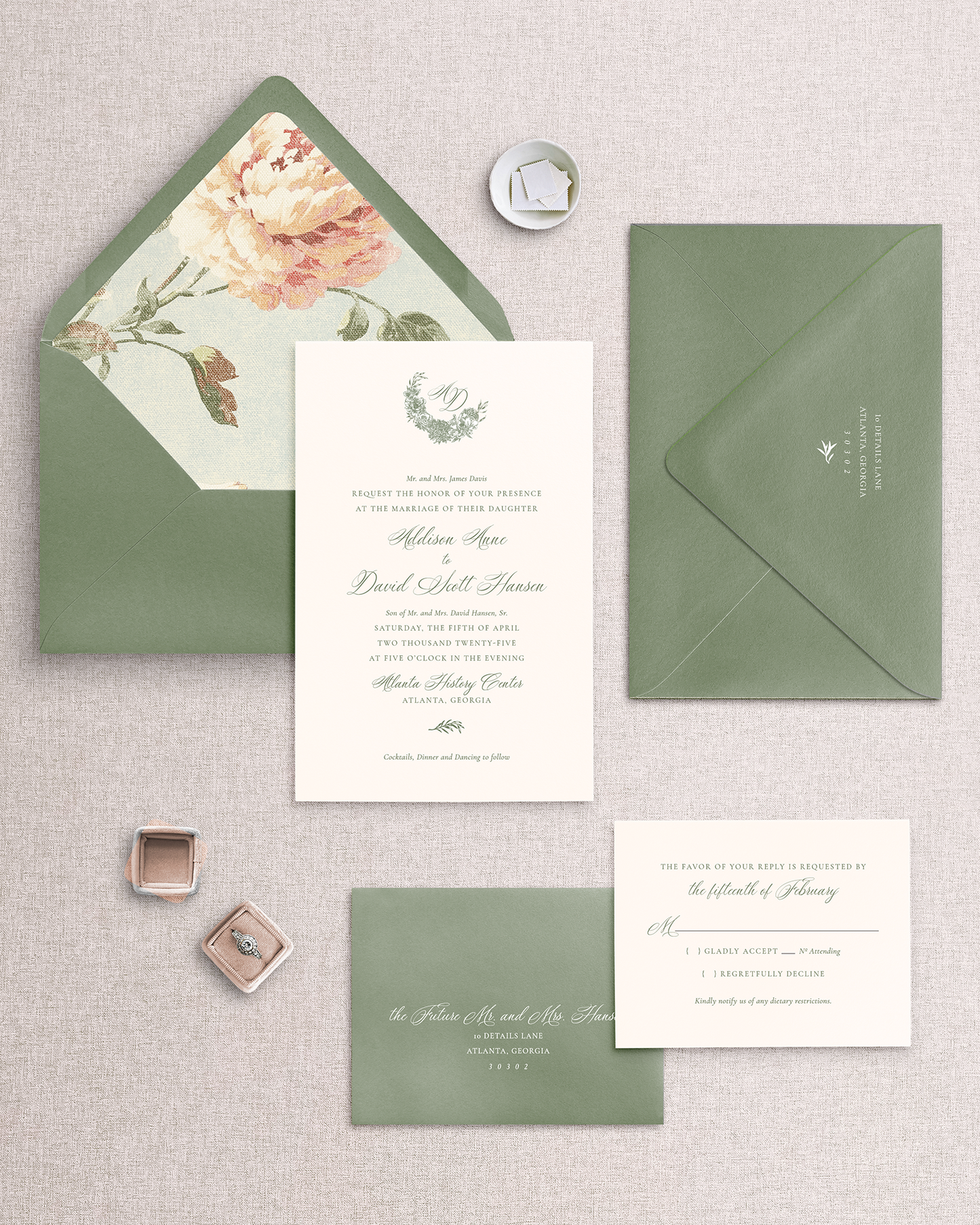 A set of wedding invitation suite including invitation card, response card, both with envelopes, displayed on a neutral background. The invitation has a floral design and the envelopes are in a green shade.