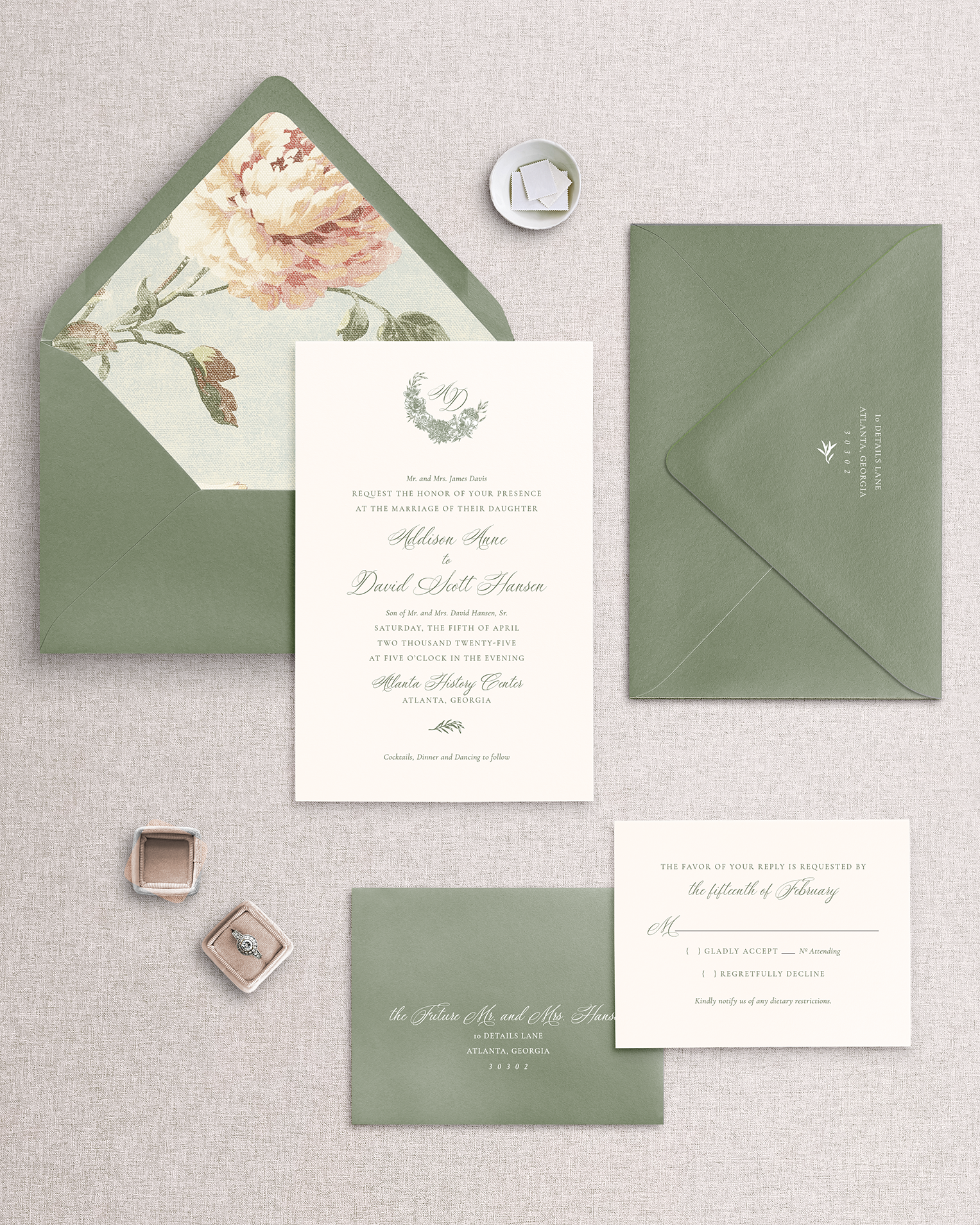 A set of wedding invitation suite including invitation card, response card, both with envelopes, displayed on a neutral background. The invitation has a floral design and the envelopes are in a green shade.