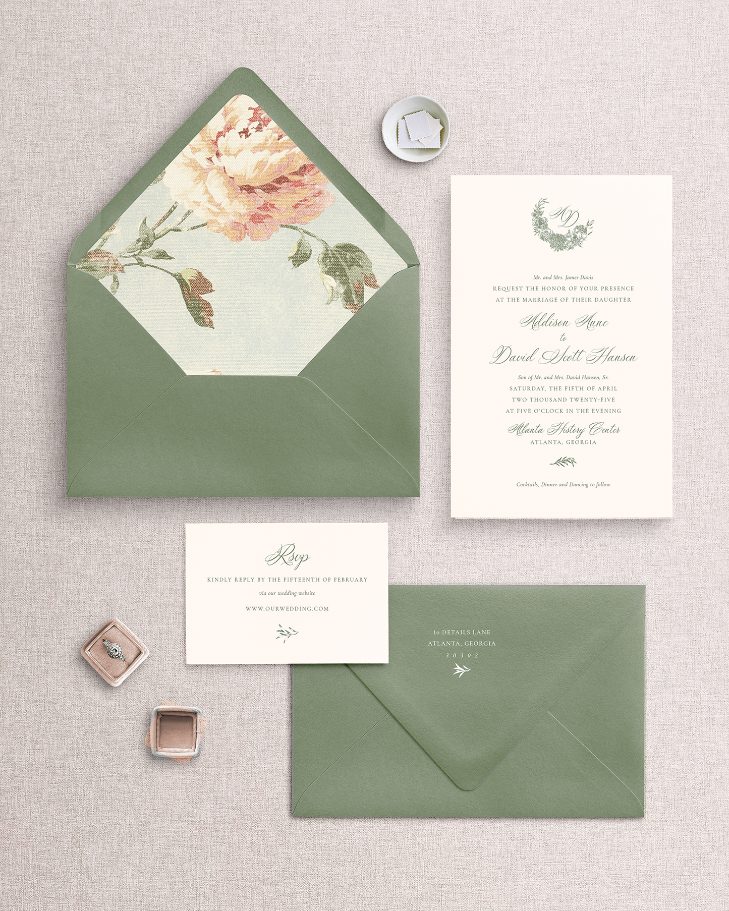 The Addison 3 piece invitation suite laid out on a surface, including a green envelope with a floral liner, a matching green invitation card, and a reply card with an envelope.