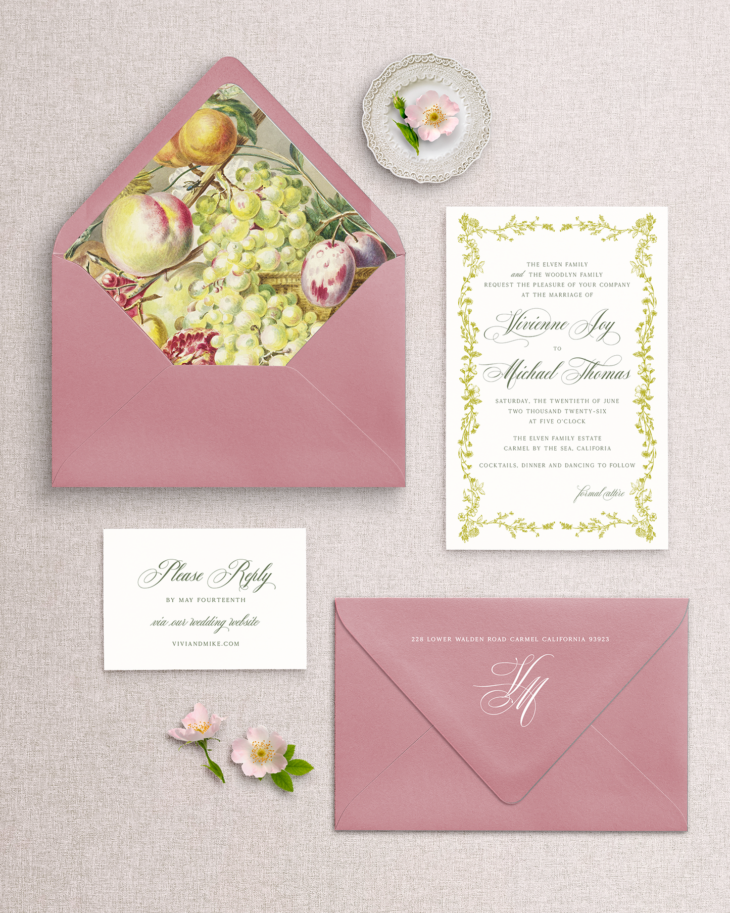 Wedding invitation set with pink envelopes and floral design on a textured surface