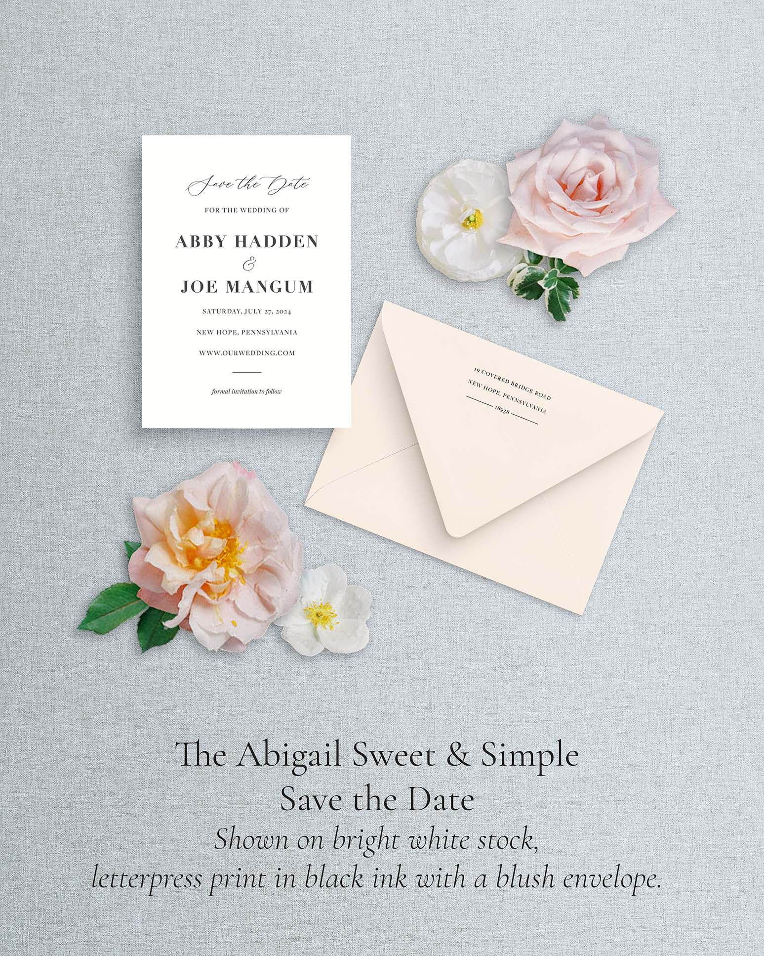 A lettepress save the date with black ink and blush envelope - there are pink and white flowers surrounding the save the date - all on a blue linen background