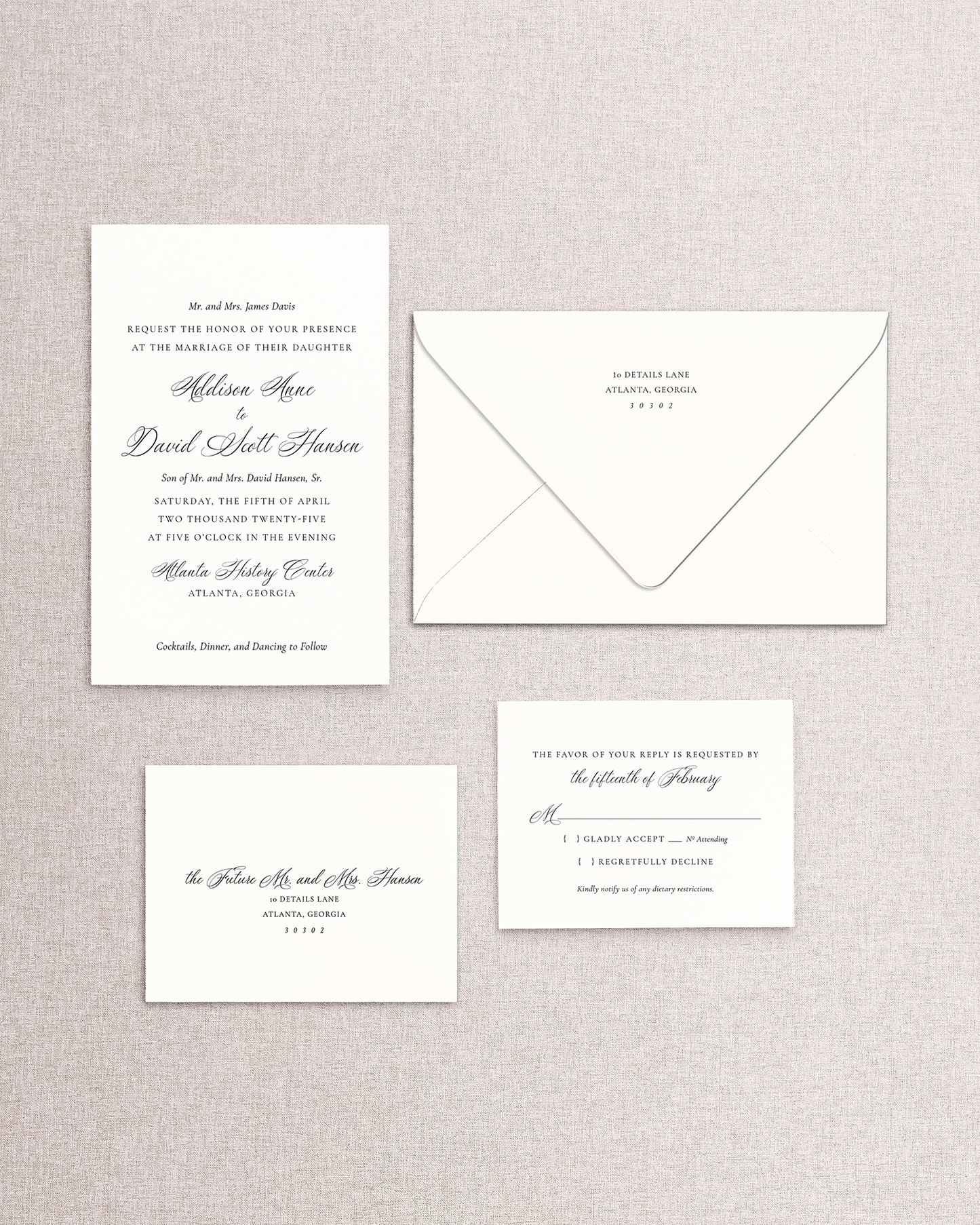 Set of wedding invitations and RSVP card on a textured gray background