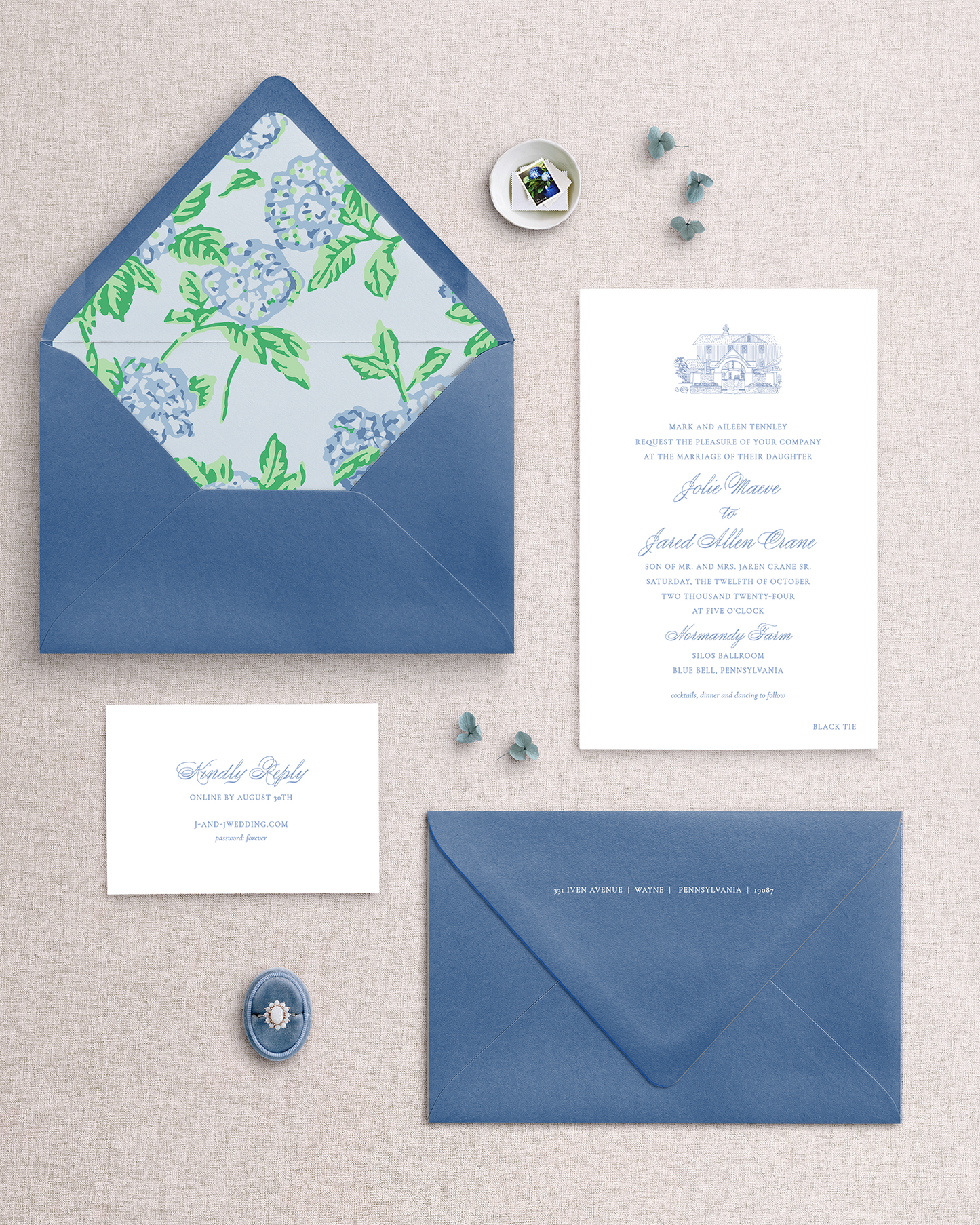 Blue envelopes and stationery items with floral design on a textured surface