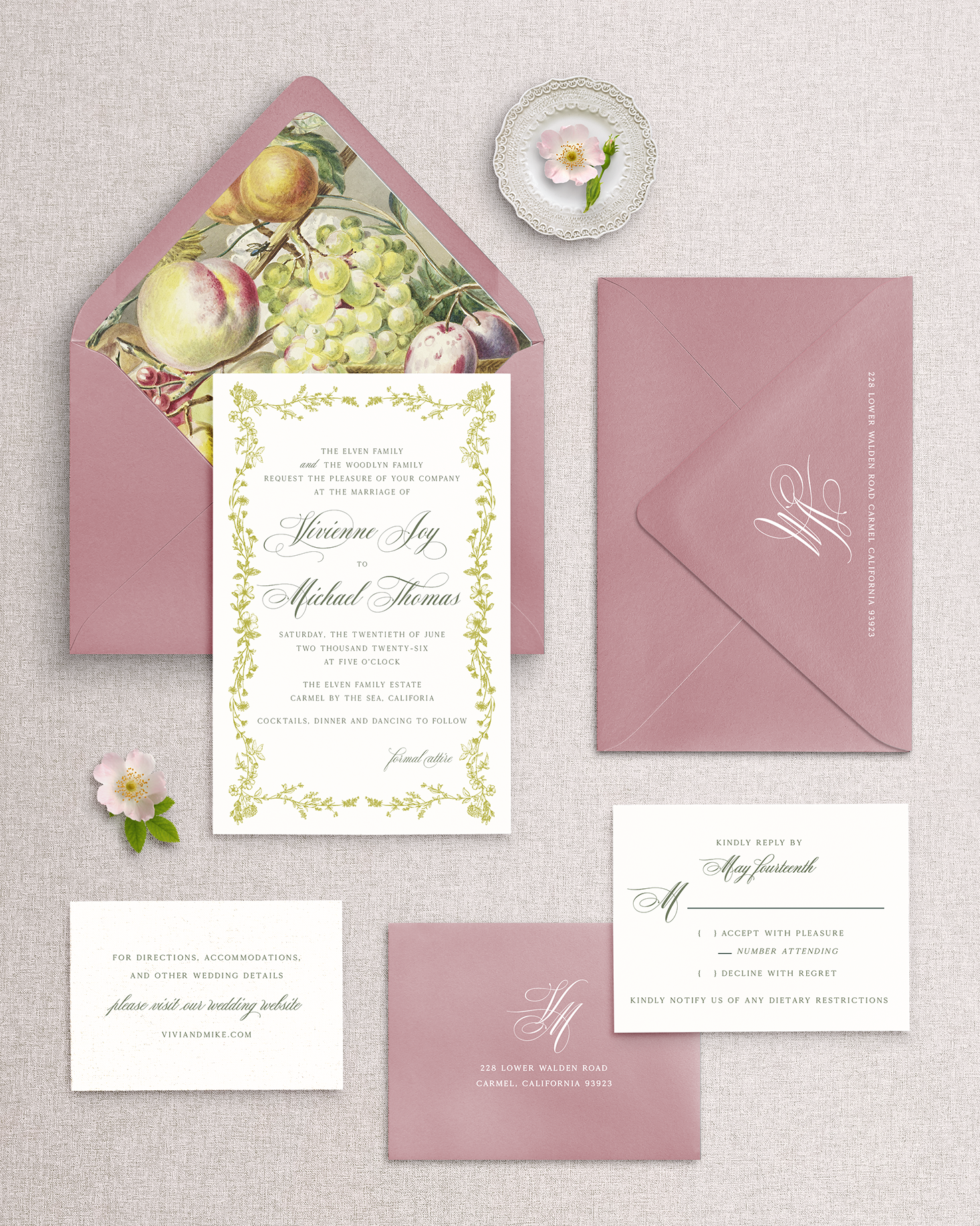 Wedding invitation set with pink envelopes and fruit-themed design on a textured surface.